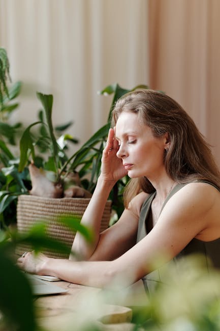 A calm and peaceful woman with eyes closed, lightly touching her face, suggesting serenity and self-care.